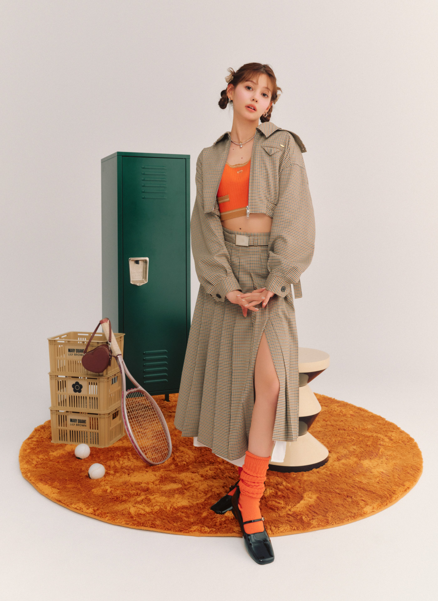 クロップドブルゾン・【LILY BROWN×MARY QUANT】クロップドニットビスチェ・ステップヘムスリットプリーツスカート・メリージェーンパンプス・【LILY BROWN×MARY QUANT】チョーカーチェーンネックレスセット・レイヤードネックレス・フープイヤリング・ローズモチーフリボンバレッタ・【LILY BROWN Lingerie】3wayハートポーチを着用した女性
