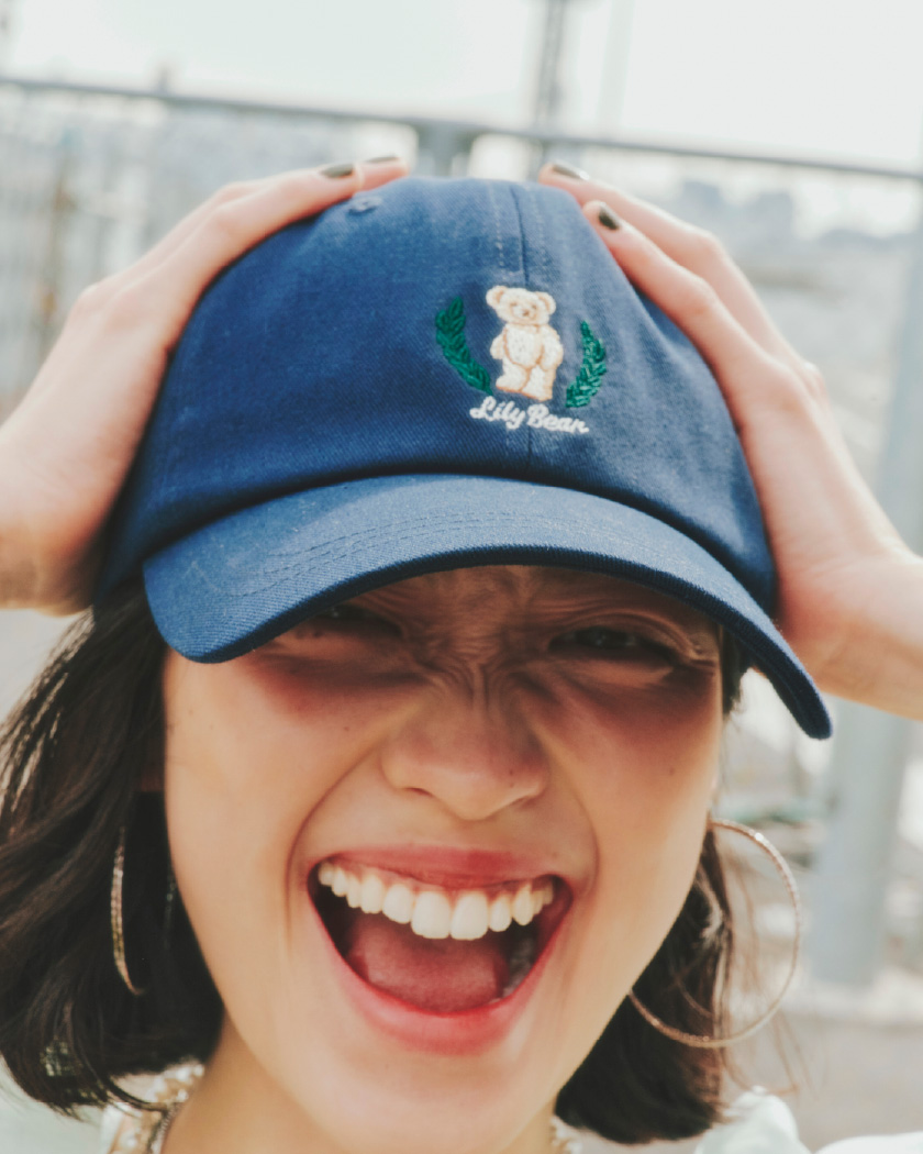 Lily Bearキャップ・Lily Bearリブソックス・パフスリーブバルーンミニワンピース・バレエシューズ・メタルコンビパールネックレス・2WAYチェーンチャームネックレス・フープピアスを着用した女性