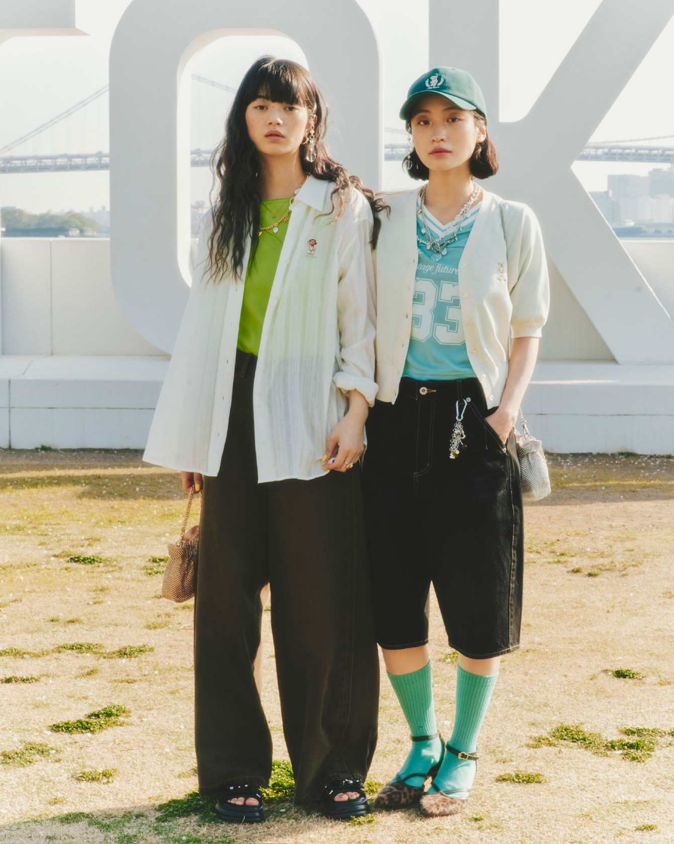 Lily Bearシアーオーバーシャツ・Lilyロゴ刺繍カップインキャミソール・ルーズフィットワイドデニムパンツ・ビジューミニショルダーバッグ・ビジュー付きスニーカーソールサンダル・カラーストーンピアス・バリエーションスリーピン・ハートストーンカラーバリエーションネックレス・2WAYチェーンチャームネックレス・ヴィンテージハートリングを着用した女性