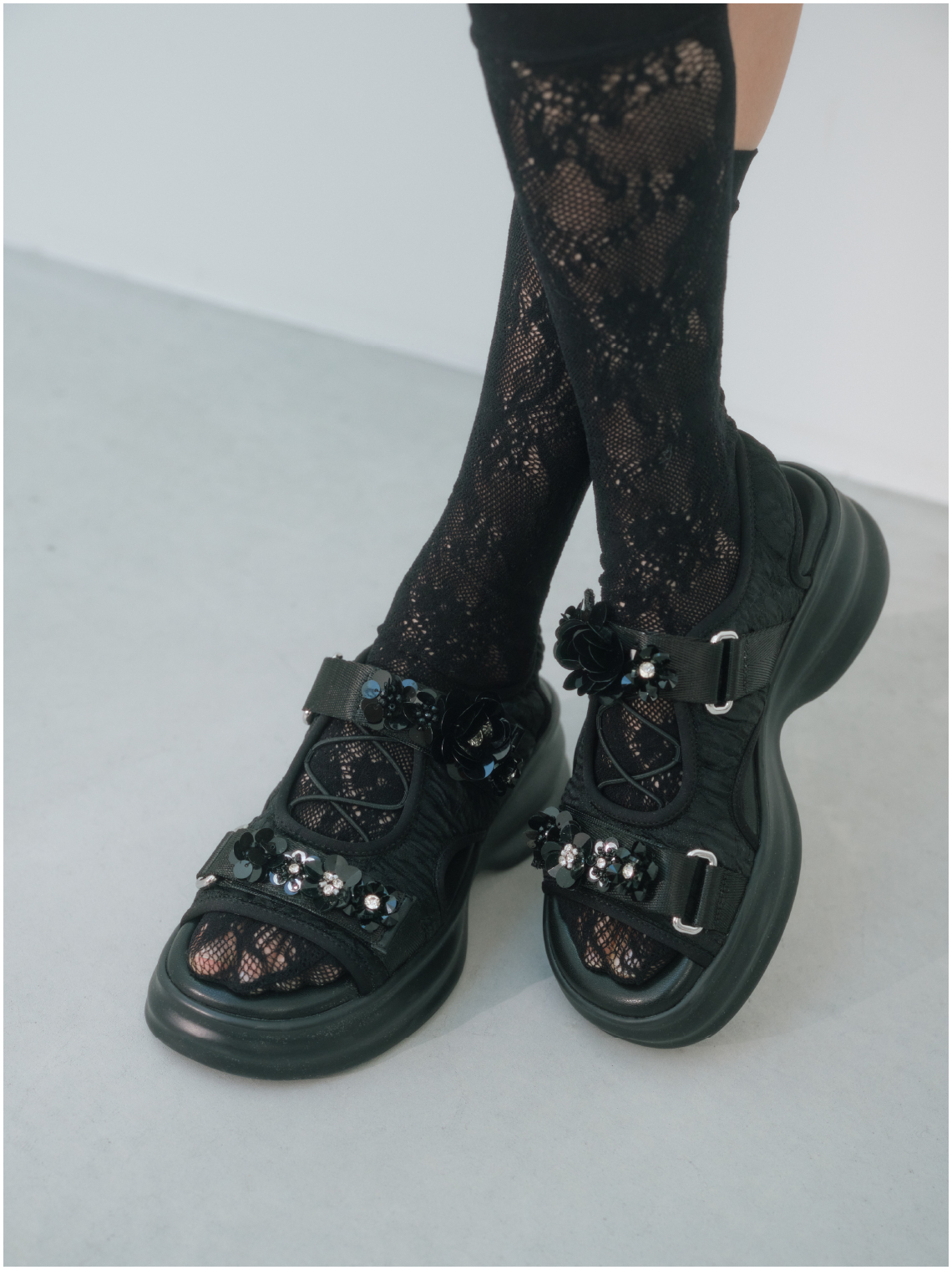[L.B CANDY STOCK]ボウタイビジューブラウス・[L.B CANDY STOCK]フラワービジューミニスカート・バリエーションスリーピン・【LILY BROWN × ANNA SUI】レースソックス・[L.B CANDY STOCK]ビジュー付きスニーカーソールサンダルを着用した女性