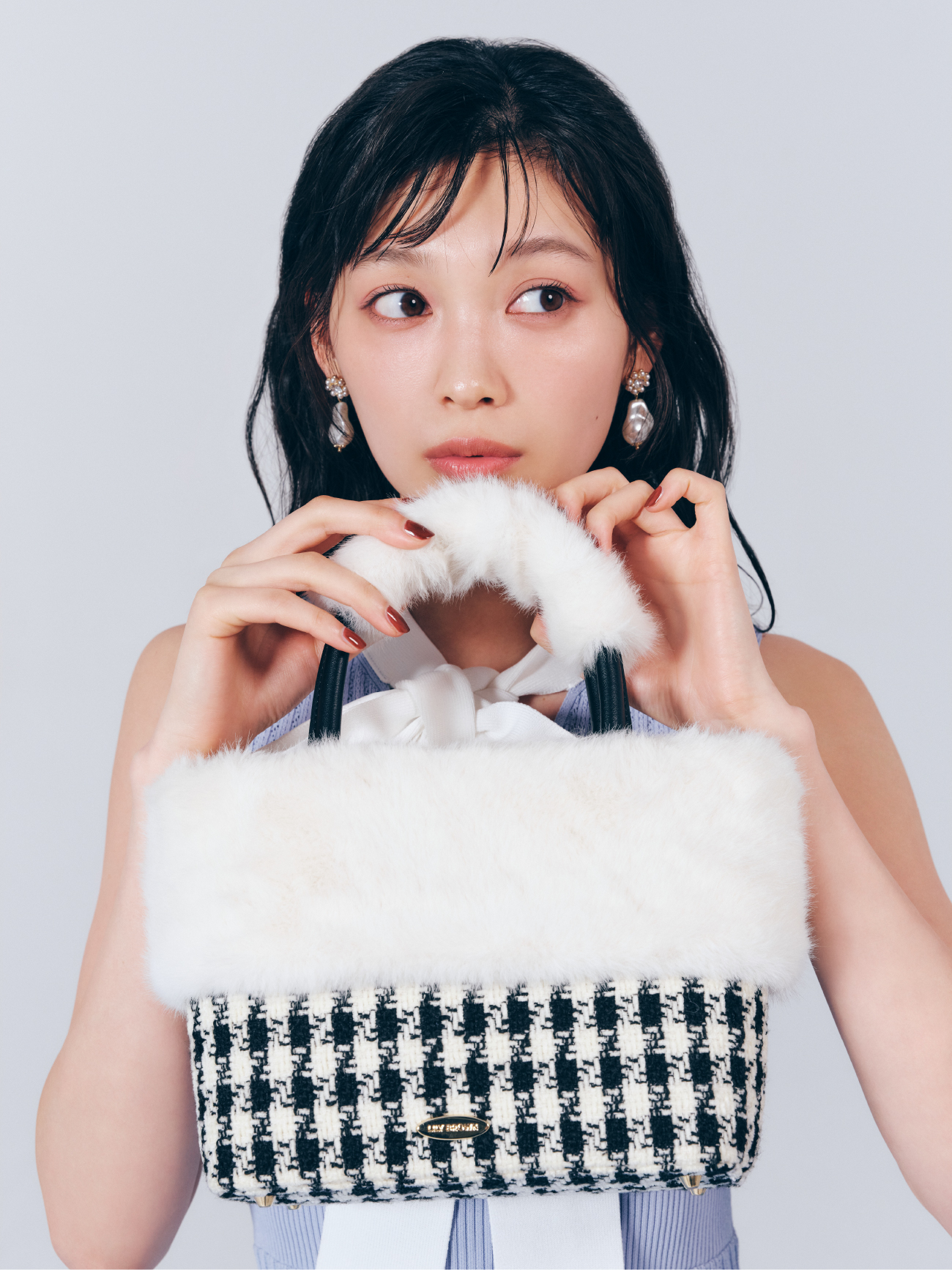 ボウタイリボンリボンニットワンピース・【限定カラー】エコファーコンビマルチウェイトートを着用した女性