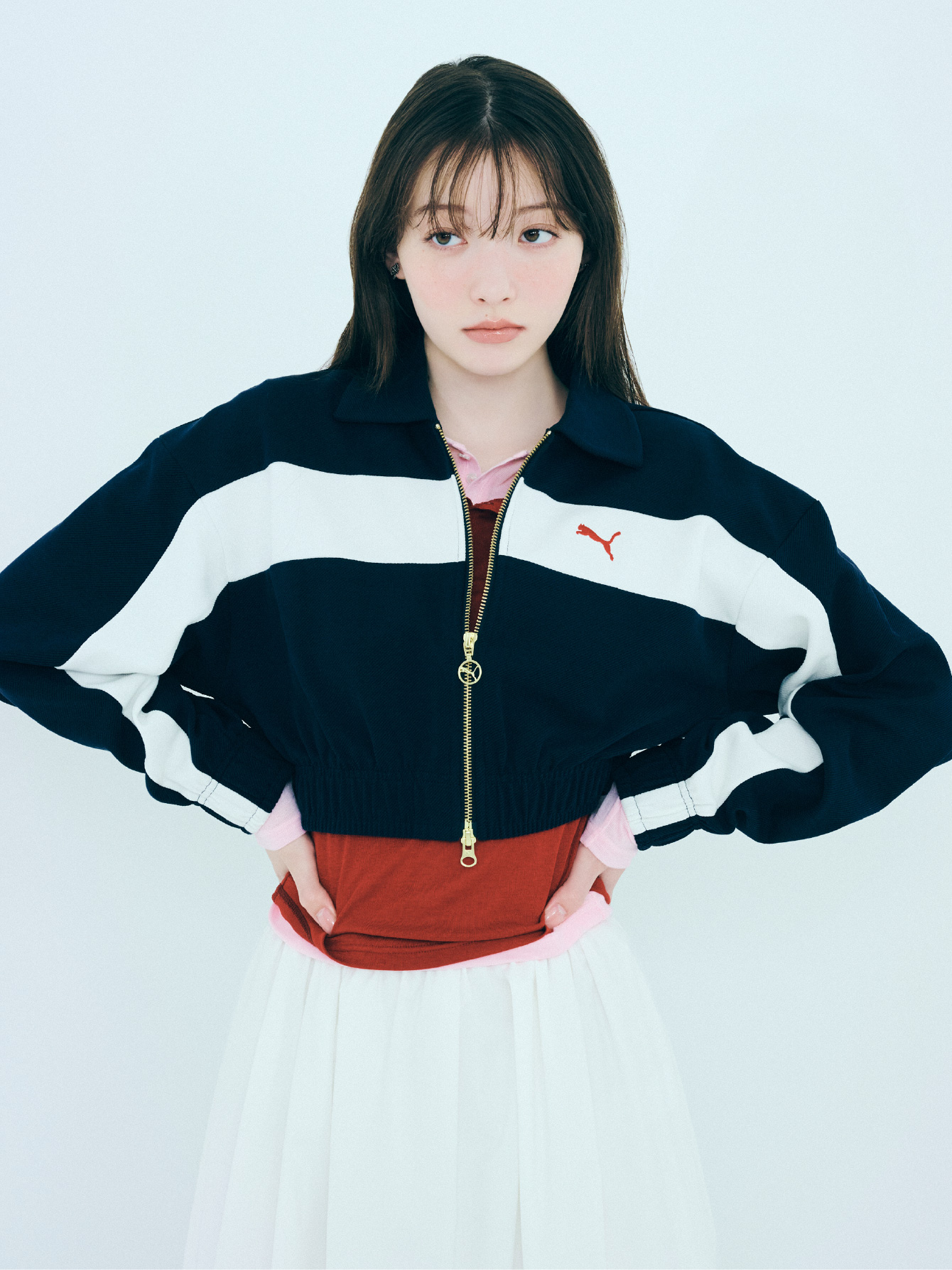 ジャケット、トップス、スカート、ピアス、ソックス、シューズを着用した女性