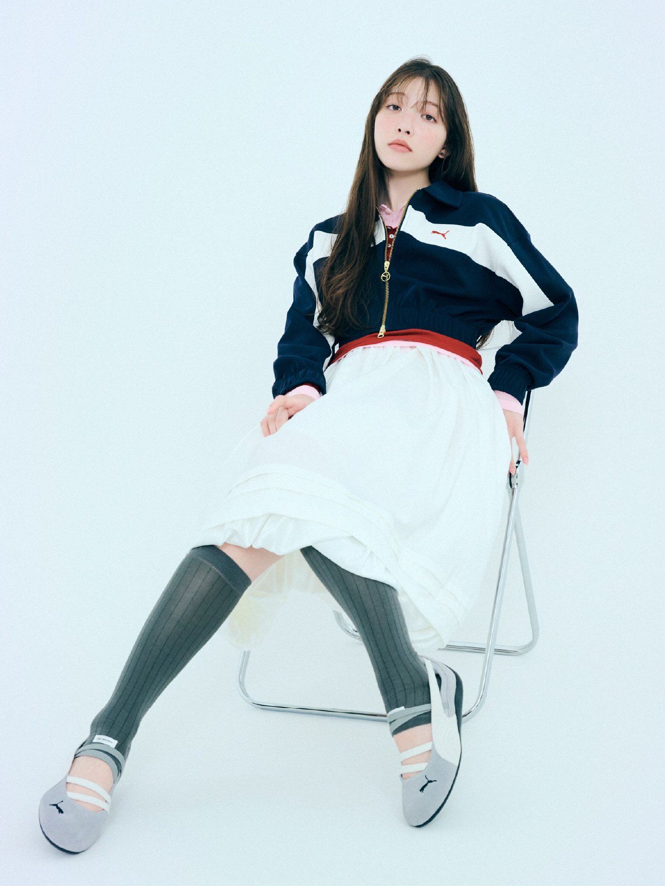ジャケット、トップス、スカート、ピアス、ソックス、シューズを着用した女性