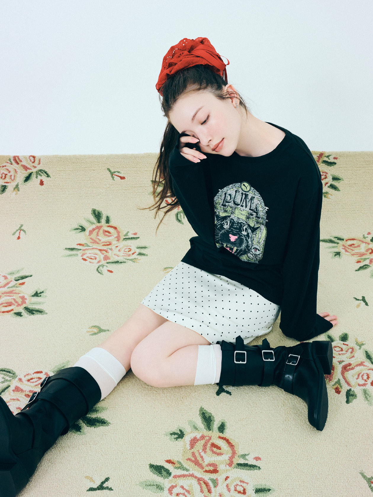 ロングTシャツ、スカート、ヘアアクセサリー、ピアス、ブーツを着用した女性