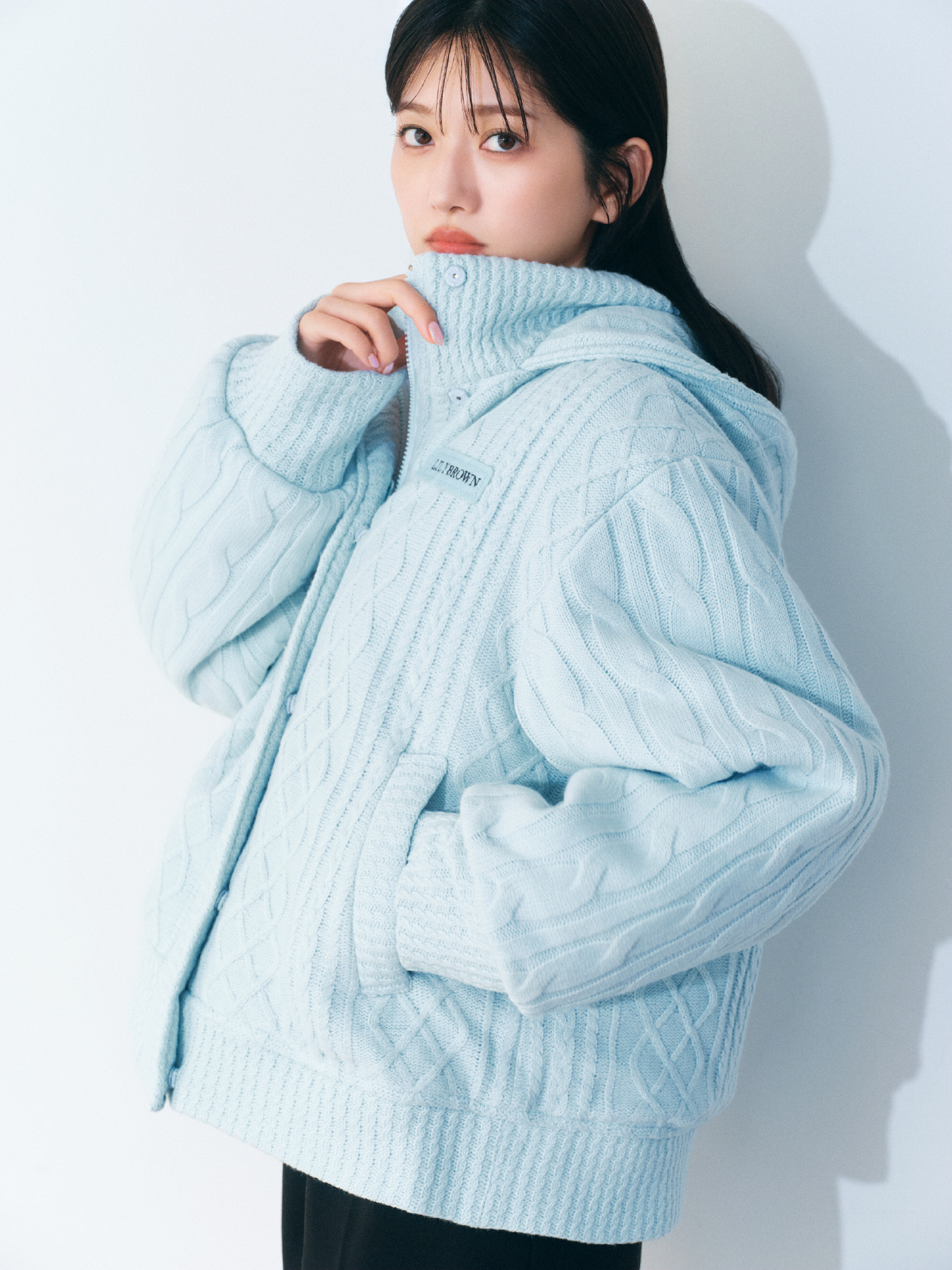 ライトブルーのニットパフジャケット・白のベロアフリルトップス・黒のベルト付きショートパンツ・銀のLilywingビジューフラワーネックレスの着用例