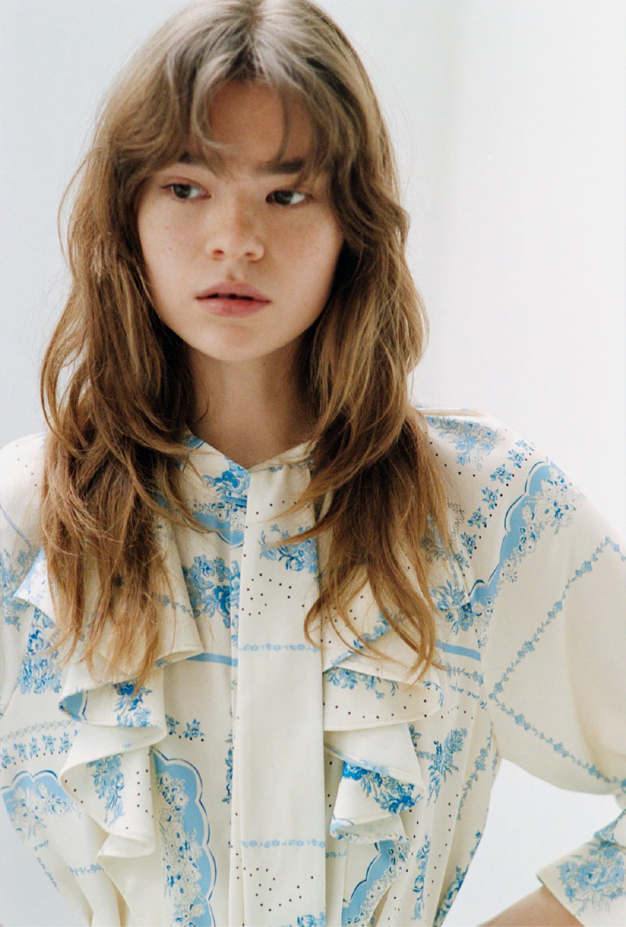 スカーフプリントボウタイブラウス＆ダブルニーカーブワイドデニムパンツ＆ウッドソールスタッズサボを着用した女性