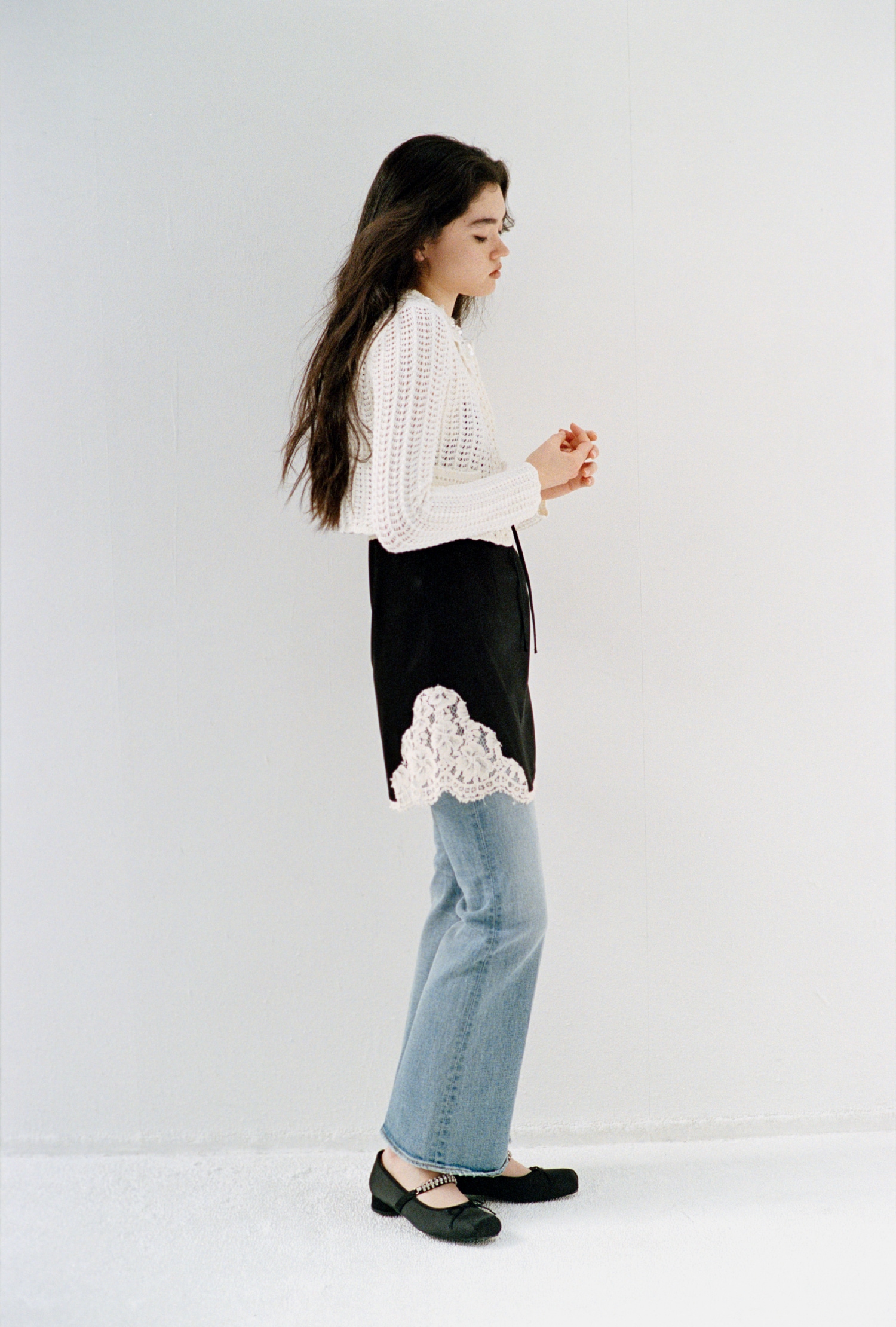 白の[L.B CANDY STOCK]クロシェ編みビジューニットカーディガン・黒のヴィンテージスリップサテンミニワンピース・ブルーのストレッチセミフレアデニムパンツ・黒の[L.B CANDY STOCK]スクエアバレエシューズ・白の[L.B CANDY STOCK]3Dフラワーバッグを合わせた、洗練されたラグジュアリーなコーディネート