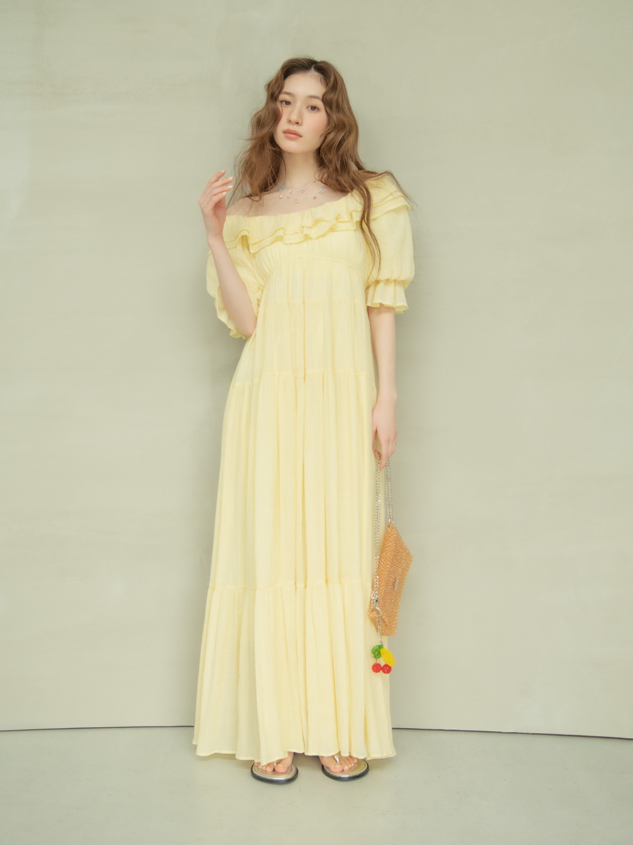 イエローのティアードロングドレスを着たモデルの全身