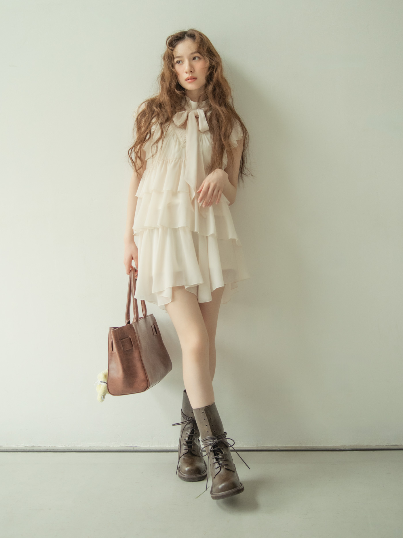 アイボリーのティアードミニドレスを着たモデルの全身