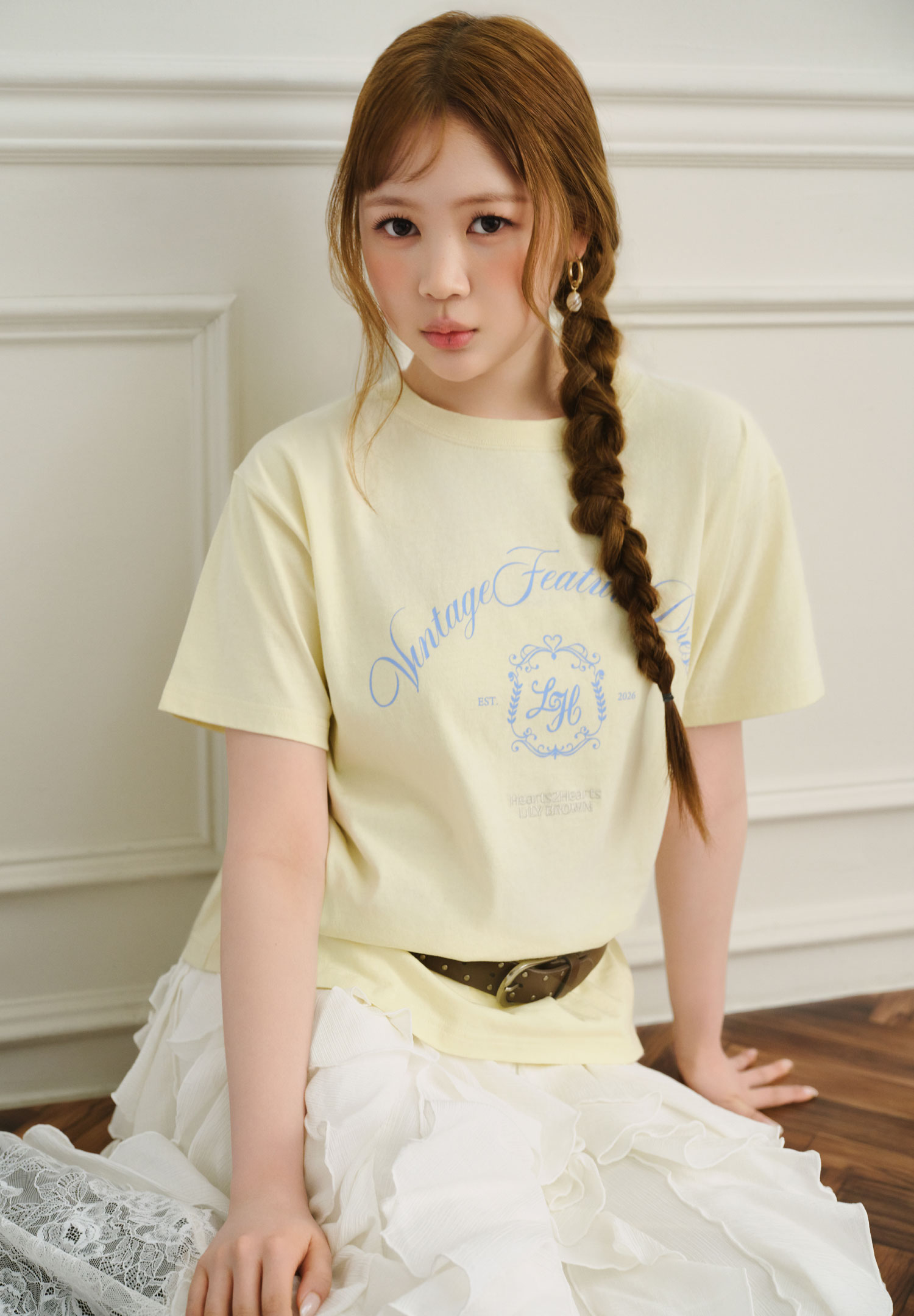 黄色のロゴTシャツを着用した女性モデルの上半身カット