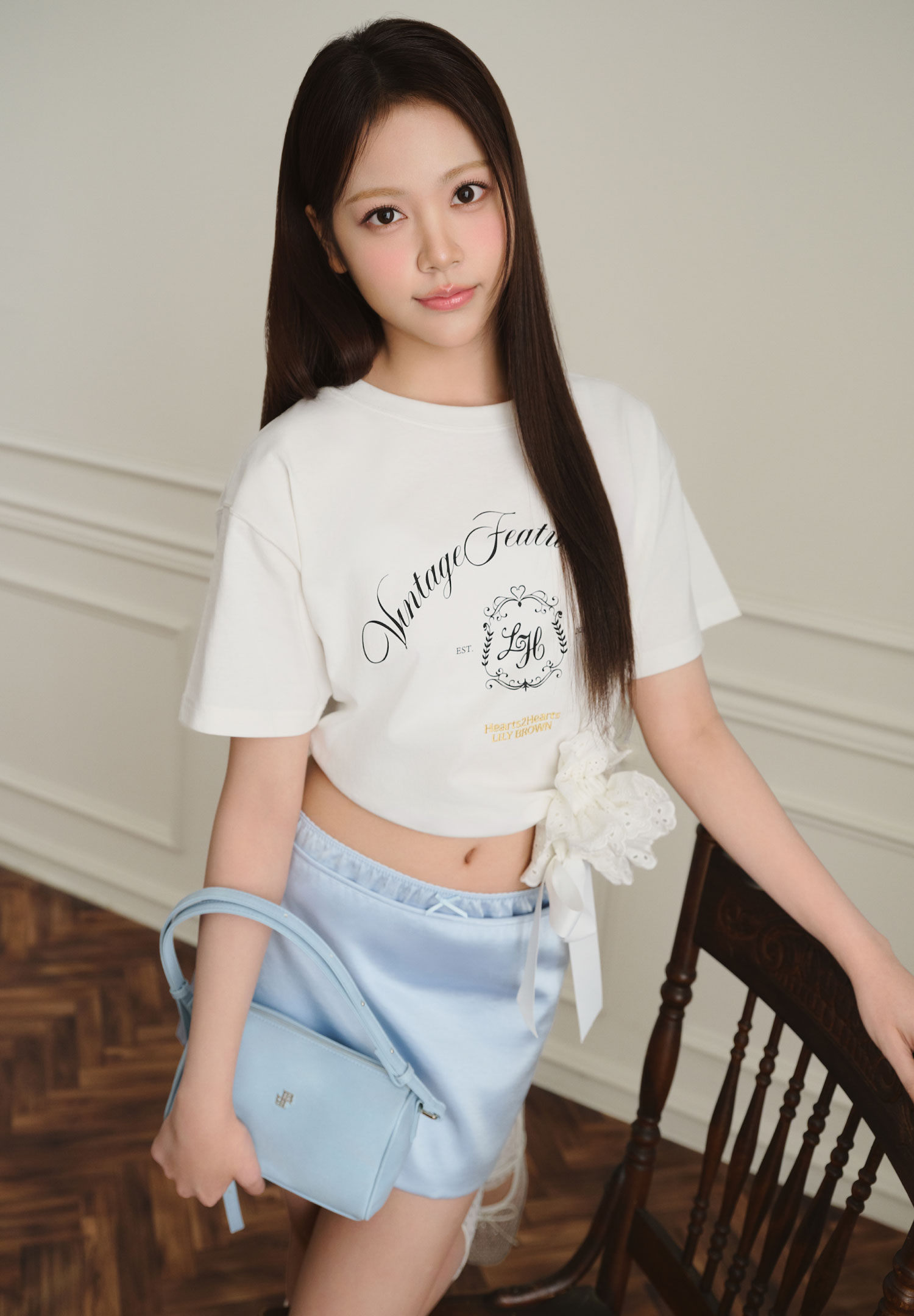 白いロゴTシャツを着用した女性モデルの上半身カット