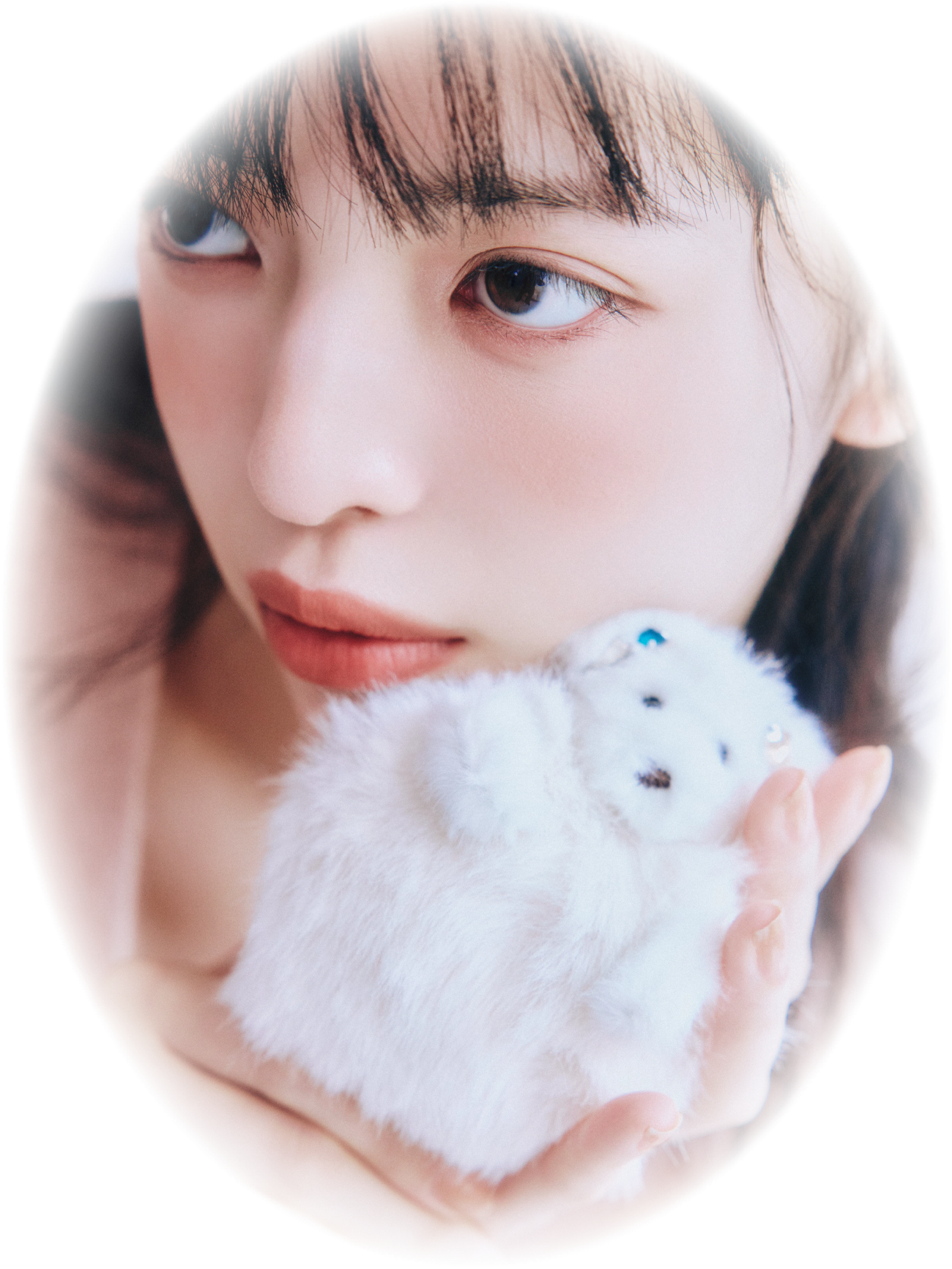 白いファーのくまのチャームを頬に寄せたモデルのアップ