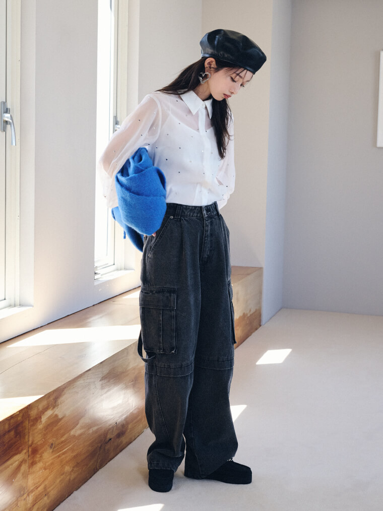 ホワイトのシャツブラウス・ブラックのカーゴデニムを履いた女性