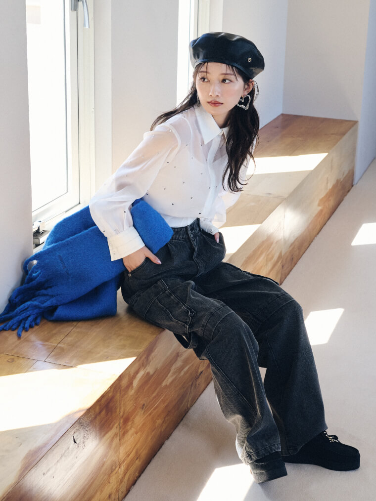 ホワイトのシャツブラウス・ブラックのカーゴデニムを履いた女性