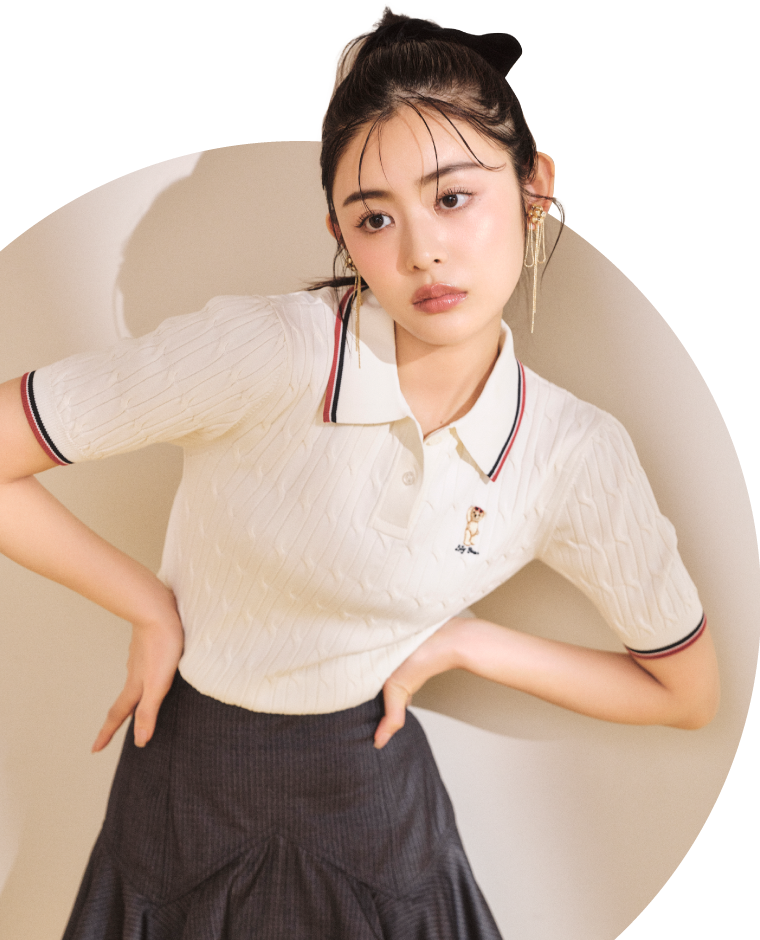 【WEB限定カラー】Lily Bearポロカラーニットプルオーバー・メモリーツイルラッフルスカショーパン・シアーレースハイソックス・リボンフラワースネークイヤリング・メリージェーンパンプスを着用した女性