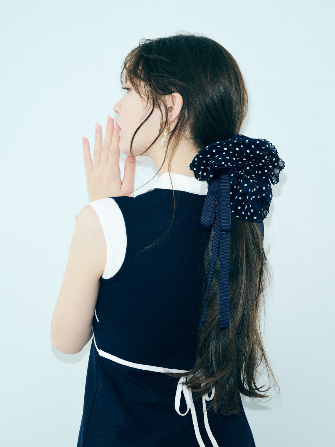 クロスカラーワンピース・LBビットフィットロングブーツ・バリエーションリボンシュシュを着用した女性