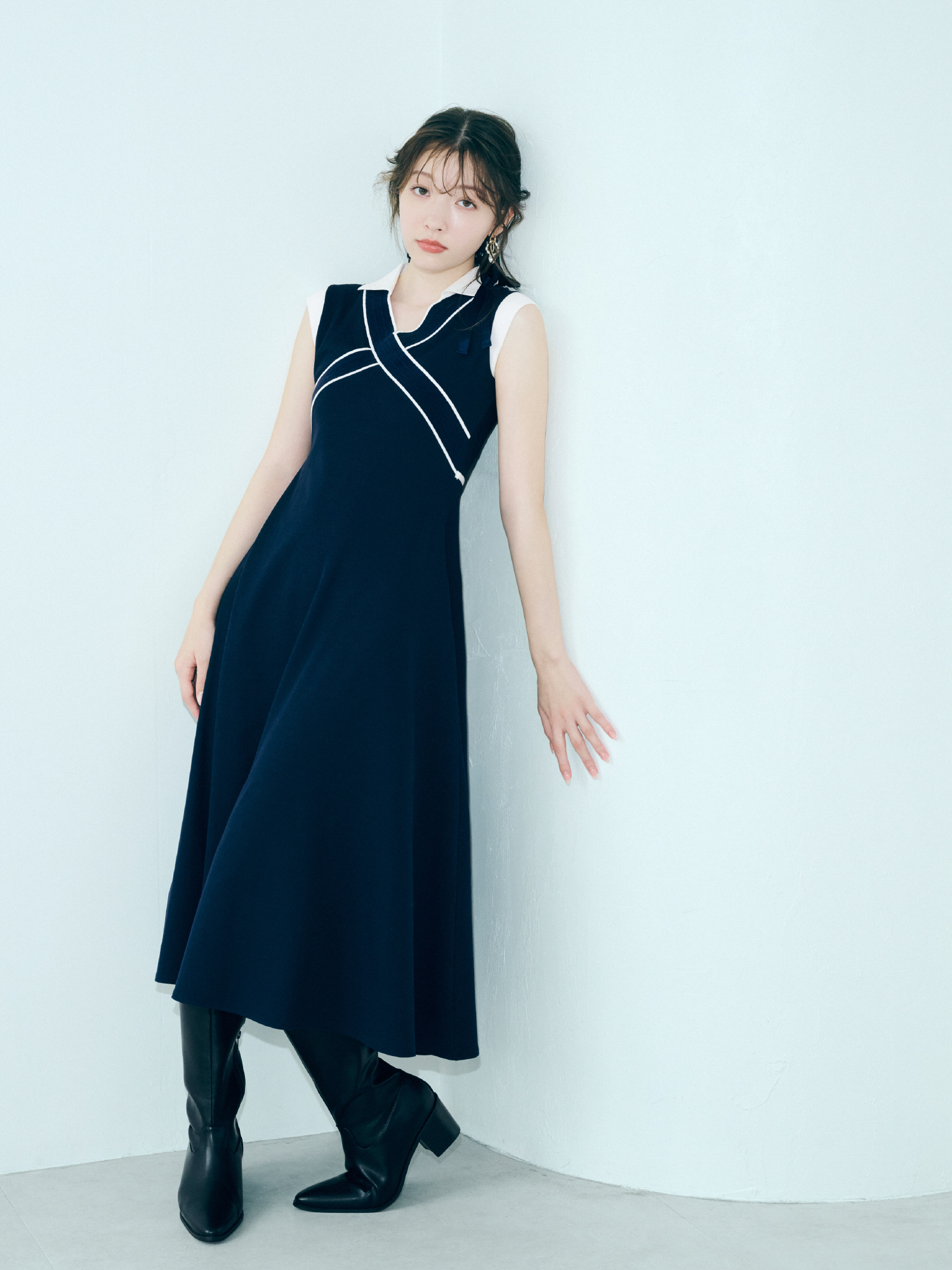 クロスカラーワンピース・LBビットフィットロングブーツ・バリエーションリボンシュシュを着用した女性