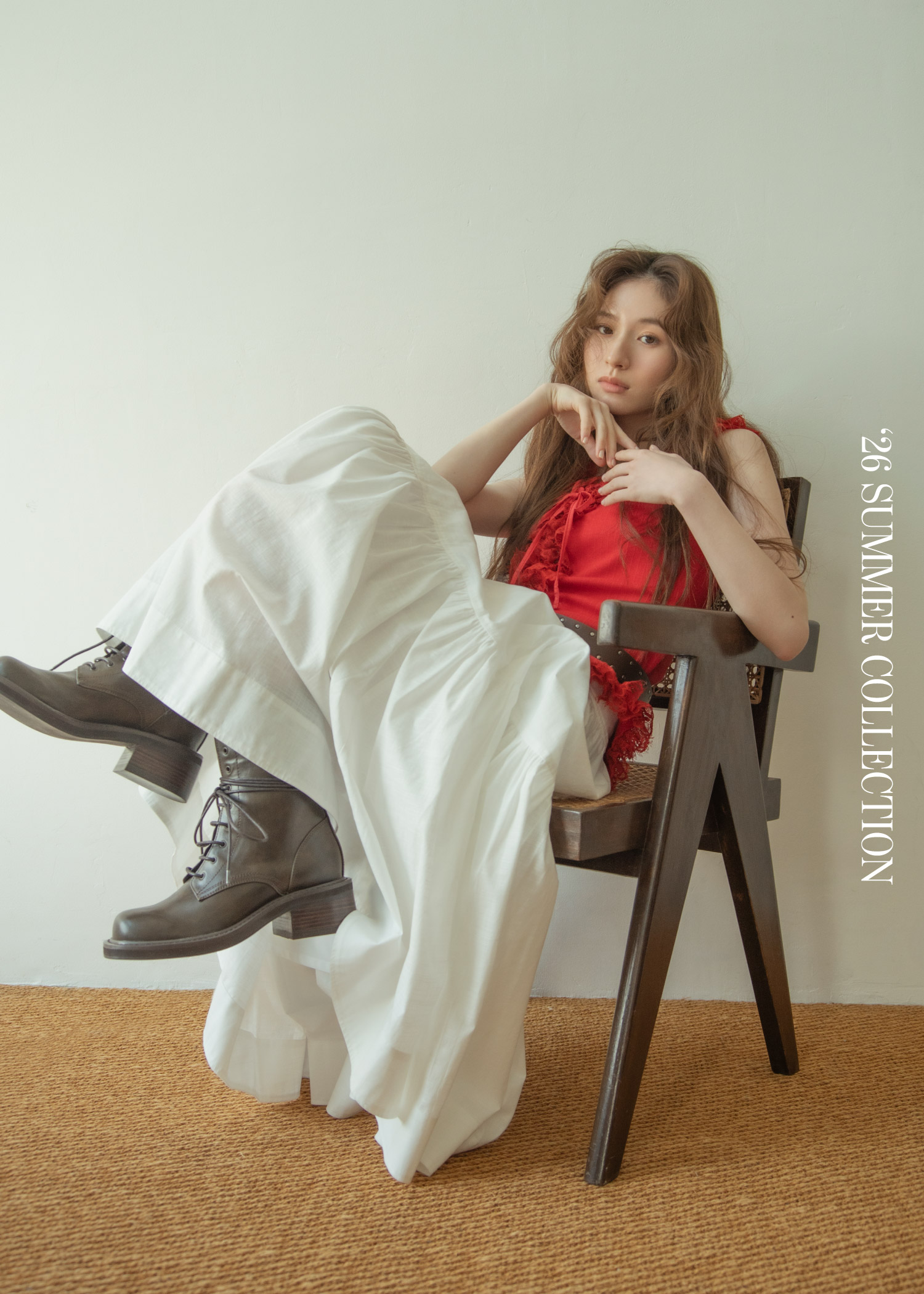 レッドのトップス・ホワイトのスカート・ブラウンのベルト・ブラウンのブーツを着用した女性