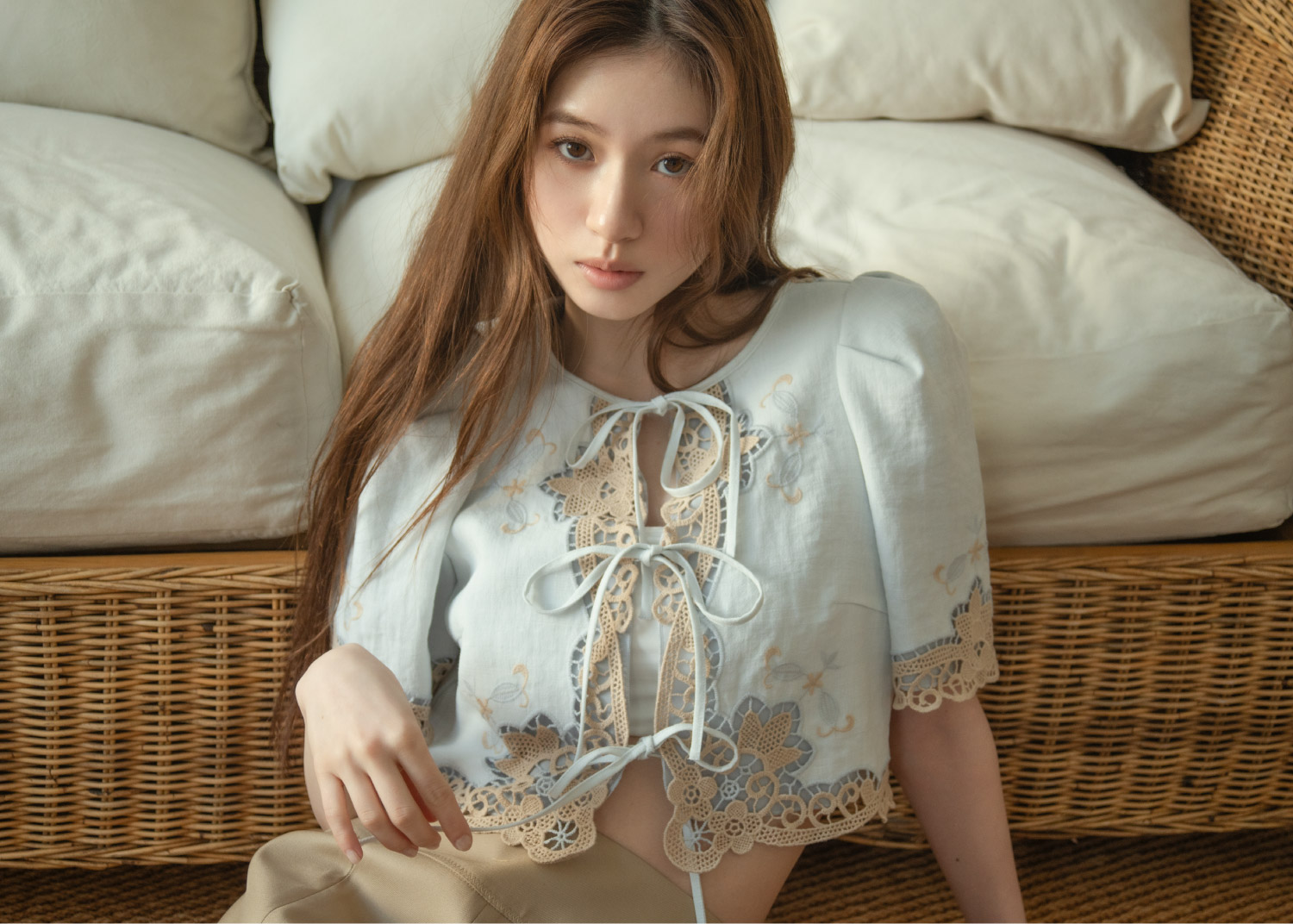 刺繍入りのブラウスとショートパンツに、パールをあしらったベージュの厚底サンダルを合わせた女性のコーディネート。