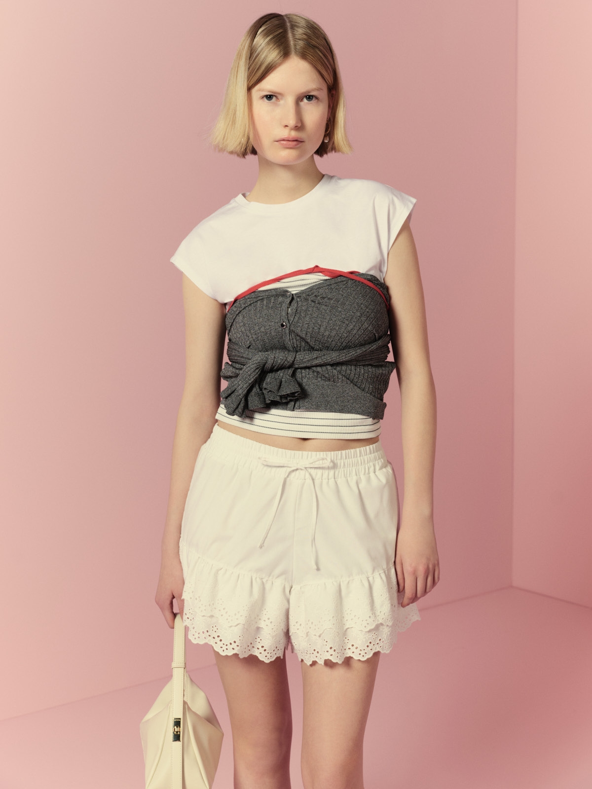 チュールビスチェセットTシャツ・フリルスリーブカーディガン・【LILY BROWN×FRUIT OF THE LOOM】ホルターネックカップイントップス・レーシーショートパンツ・LBロゴショルダーバッグ・ドロップパールピアスを着用した女性