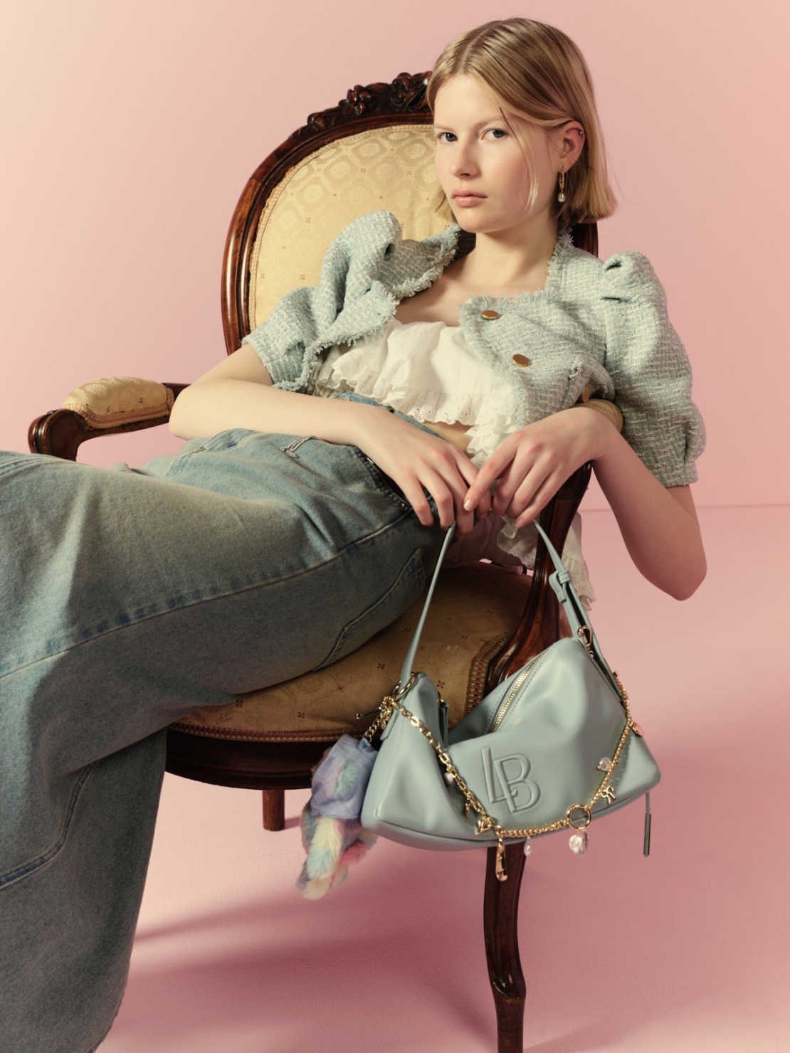 ハーフスリーブツイードジャケット・スイッチングマーメイドスカート・LBロゴショルダーバッグ・ドロップパールピアス・Lily Bear スカーフスタイルチャーム・2WAYチェーンチャームネックレス・ミラー付きキーリング・ウエスタンブーツを着用した女性