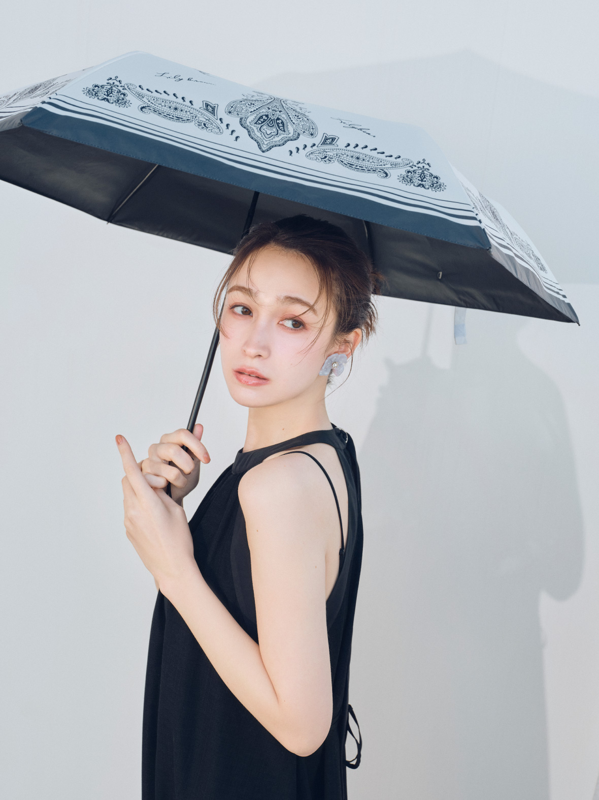 カップインベアセットアメスリワンピース・ミッドヒールサンダル・Lily Bear晴雨兼用日傘・クリアフラワーイヤリングを着用した女性